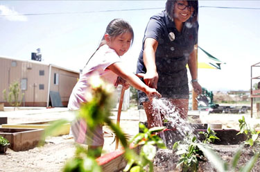 Girl waters a garden in Shiprock, NM